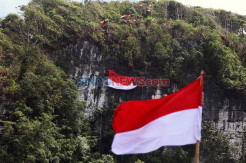 Pemuda-Pemudi Pulau Bawean Kibarkan Bendera Raksasa di Tebing Karst Gunung Batu