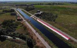 Pembentangan Kain Merah Putih Sepanjang 76 Meter di Bantaran Sungai Cikijing