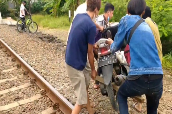 Aksi Warga yang Nekat Gotong Motor Seberangi Rel Kereta Hindari Penyekatan PPKM