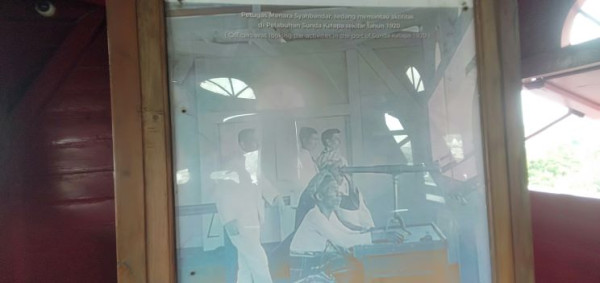 Arsip berupa foto lima petugas meneropong dari atas Menara Syahbandar Jakarta, sekitar 1920.