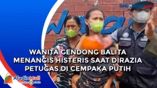 Wanita Gendong Balita...
